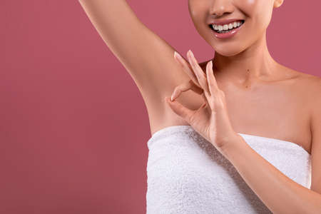 Asian woman lifting hand up, showing clean and hygienic armpitsの写真素材