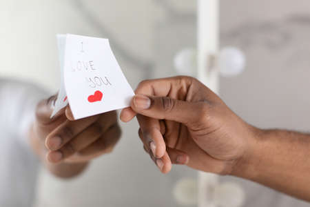 Male Hand Putting Sticky Note With I Love You Text On Mirrorの写真素材