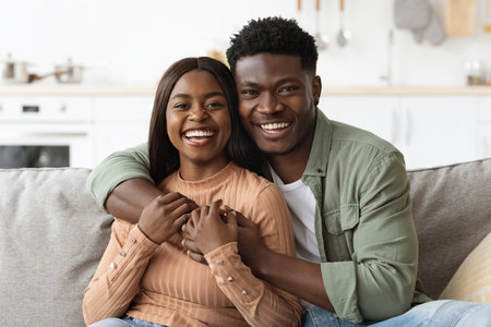 Closeup portrait of happy black couple, home interiorの写真素材
