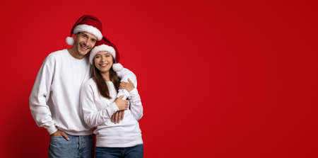 Merry Christmas. Happy Spouses In Santa Hats Embracing And Smiling At Camera