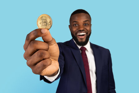 Cryptocurrency Mining. Portrait Of Happy Black Businessman In Suit Holding Golden Bitcoinの写真素材