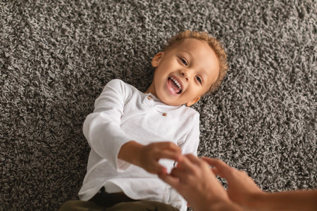 Black Little Boy Laughing Lying While Mommy Tickling Him Indoor