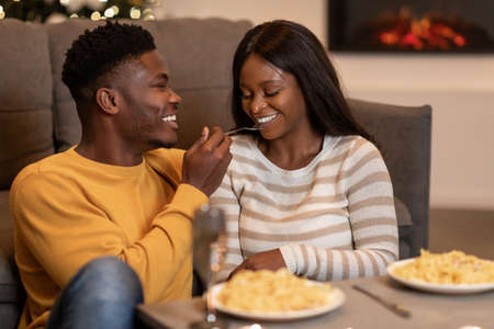 African Couple Having Romantic Dinner Eating Pasta On Valentines Indoorの写真素材
