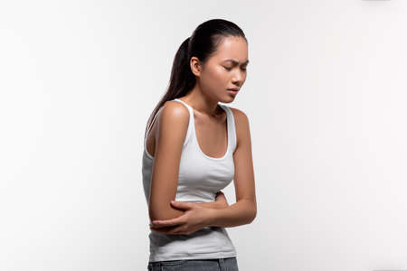 Korean woman in pain touching her belly, liver disease conceptの写真素材