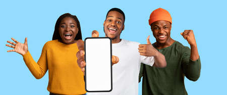 Cool african american friends enjoying online offers, showing cellphone, mockupの写真素材