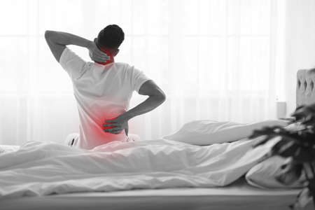 Unrecognizable Man Rubbing Painful Back And Neck After Waking Up In Morning
