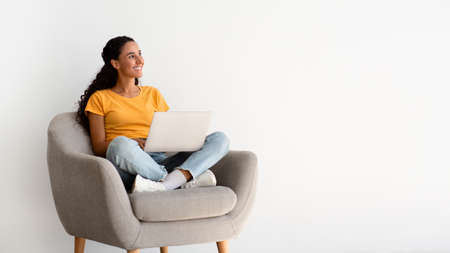 Online Offer. Smiling Young Woman With Laptop On Laps Sitting In Armchair