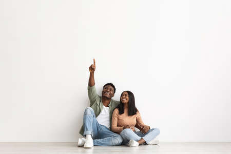 Happy black guy showing his girlfriend somethingの写真素材