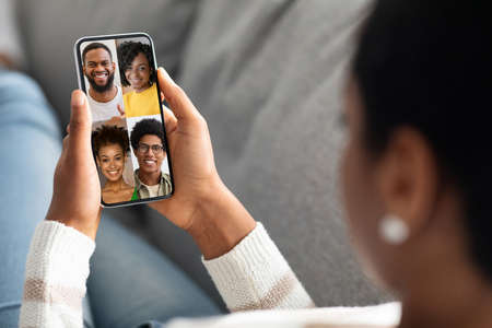 Female holding cellphone with happy black people faces on screen