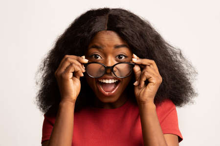 Wow. Surprised Black Female Taking Off Glasses, Looking At Camera With Excitementの写真素材