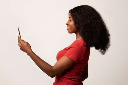 Biometric Identification. Smiling Black Female Using Face Recognition App On Smartphoneの写真素材