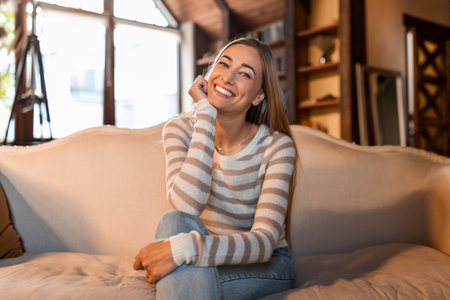 Calm woman having rest at home posing on the couchの写真素材