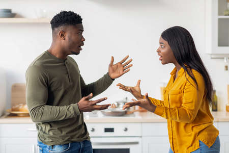 Domestic Conflicts. Young Black Spouses Arguing In Kitchen, Suffering Relationship Problemsの写真素材