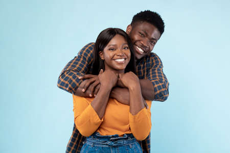 African American lady cuddling with her happy manの写真素材