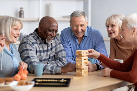 Multiracial senior people playing board at homeの写真素材