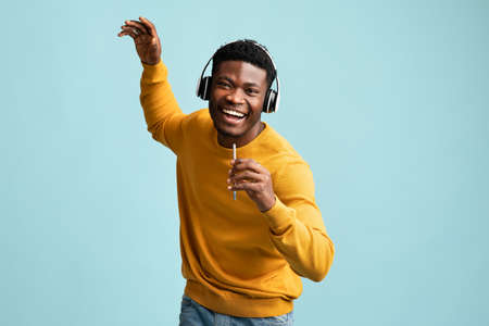Handsome african american man with headset and smartphone singingの写真素材