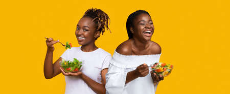 Portrait of Smiling Black Ladies Holding Plate With Saladの写真素材