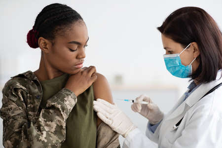 Military Vaccination. African American Soldier Lady Getting Vaccine Shot Against Coronavirusの写真素材