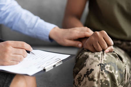 Closeup Shot Of Psychotherapist Supporting African American Soldier Woman During Therapy Sessionの写真素材