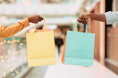 Closeup of black couple holding showing shopping bags