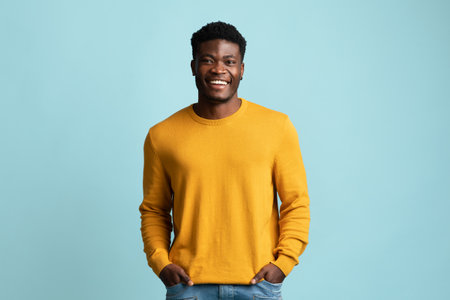 Positive african american guy holding hands in pocketsの写真素材