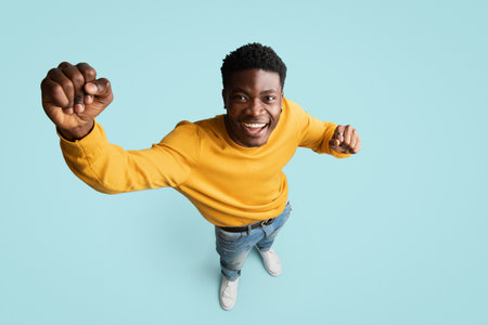 Top view of cheerful black guy gesturing on blueの写真素材