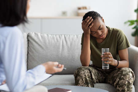 Post Military Depression. Upset Black Soldier Lady During Meeting With Psychotherapistの写真素材