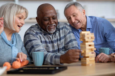 Closeup of multiracial senior people playing wooden blocks at homeの写真素材