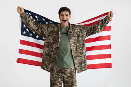 Cheerful military guy with flag of the US on whiteの写真素材