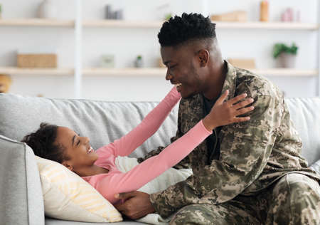 Black man soldier waking up his kid, came back homeの写真素材