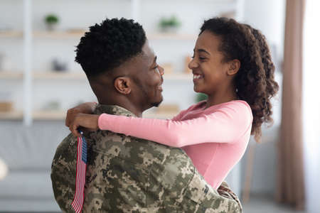 Cheerful girl with flag of the US hugging her dad