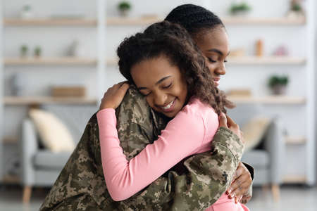Side view of mom in military uniform hugging childの写真素材