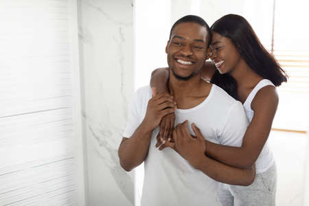 Portrait Of Young African American Couple Embracing In Bathroom Interiorの写真素材
