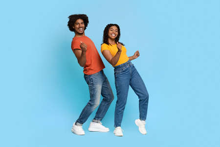 Positive african american couple posing on blue, dancingの写真素材