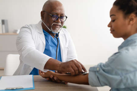 Doctor checking measuring pressure on patients hand pulseの写真素材