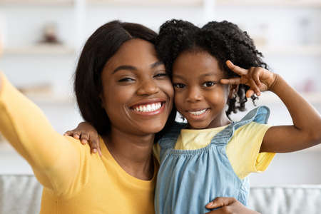 Happy Young Black Mother Taking Selfie With Little Daughter At Home, Povの写真素材