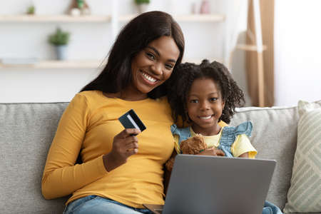 Online Payments. Black Mom And Female Child With Laptop And Credit Cardの写真素材