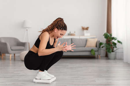 Unhappy Fitness Lady Standing On Scales Shouting Weighing At Home