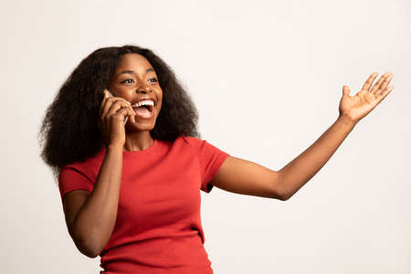Portrait Of Excited African American Woman Talking On Mobile Phoneの写真素材
