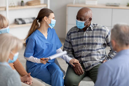 Senior black man getting psychological support from female therapistの写真素材