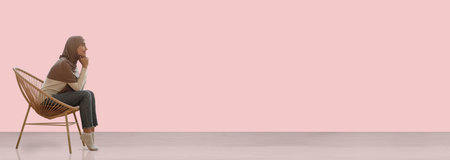 Muslim lady in hijab relaxing in wicker chair, copy spaceの写真素材