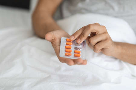Sick Man Holding Blister Pack With Pills, Taking Medicine At Home