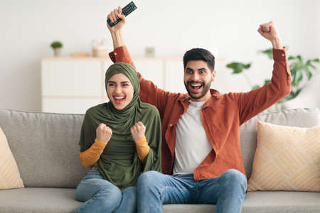 Emotional Middle Eastern Couple Shouting Watching Sport On TV Indoorの写真素材