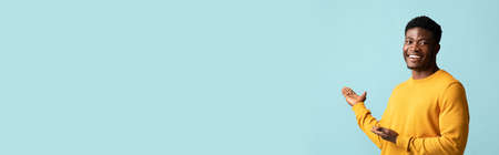 Happy black man in casual pointing at copy spaceの写真素材