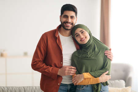Loving Middle Eastern Couple Embracing Standing At Homeの写真素材