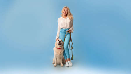 Young woman posing with her dog on a leash