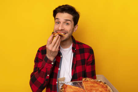 Happy Guy Holding Box Biting Pizza At Orange Studioの写真素材