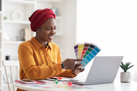 Stylish young black woman independent contractor having video conferenceの写真素材