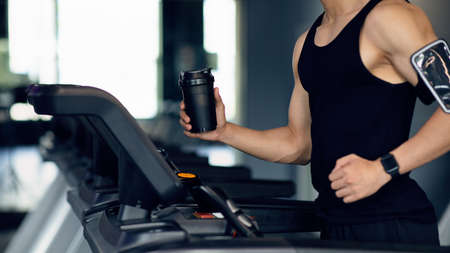 Sporty Lifestyle. Unrecognizable Male Athlete Jogging On Treadmill At Modern Gym