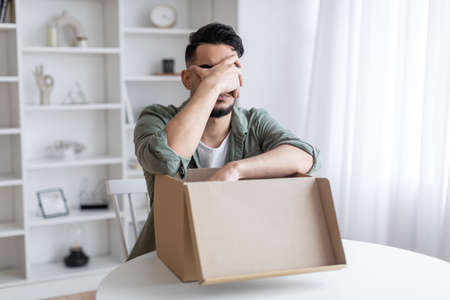Wrong Item. Upset Arab Guy Opening Parcel And Making Facepalm Gestureの写真素材